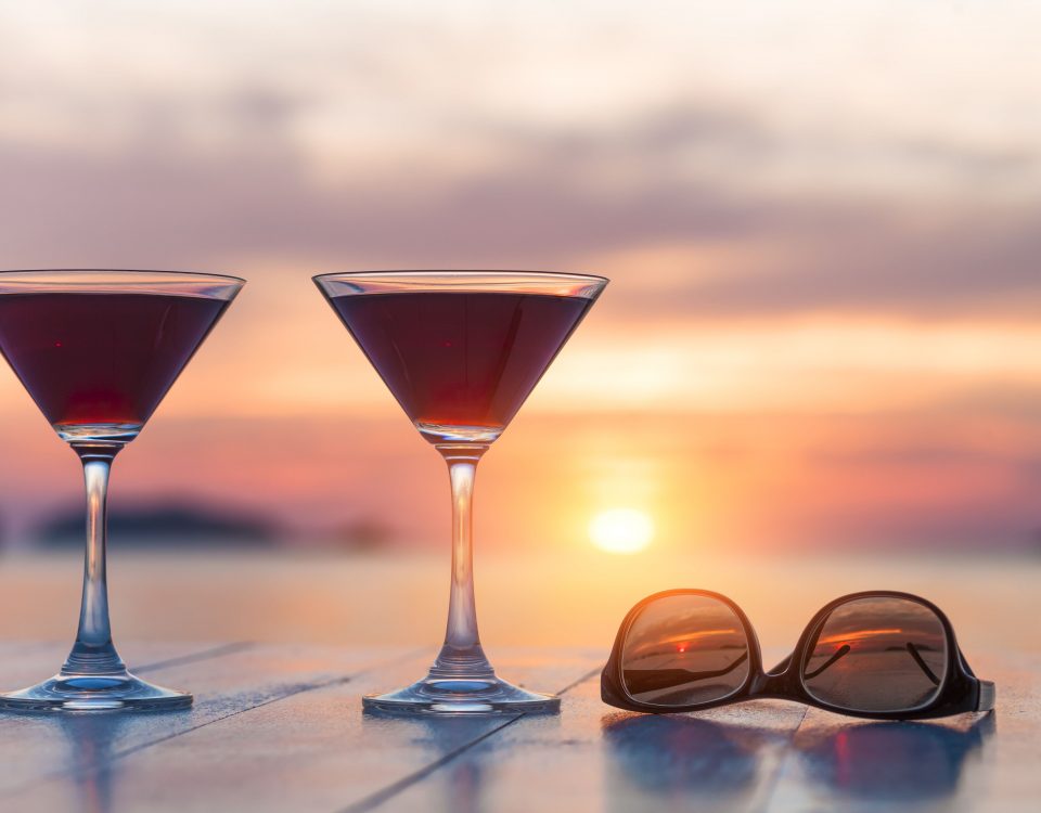 Zweic Cocktails und eine Sonnenbrille vor Sonnenuntergang