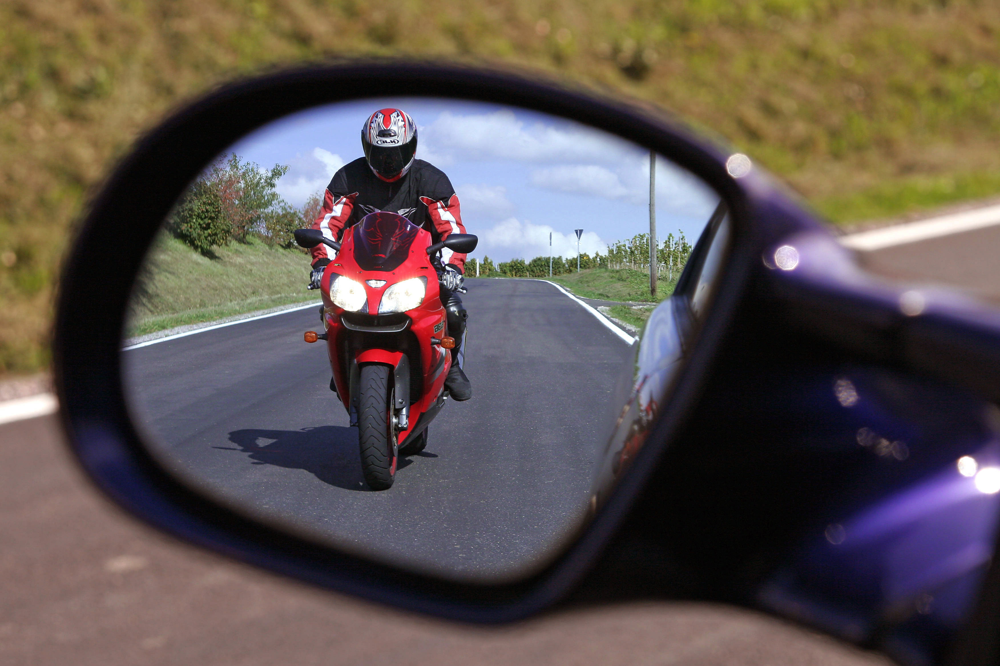 Shotshop/Rüdiger Rebmann Motorradfahrer nähert sich Autofahrer