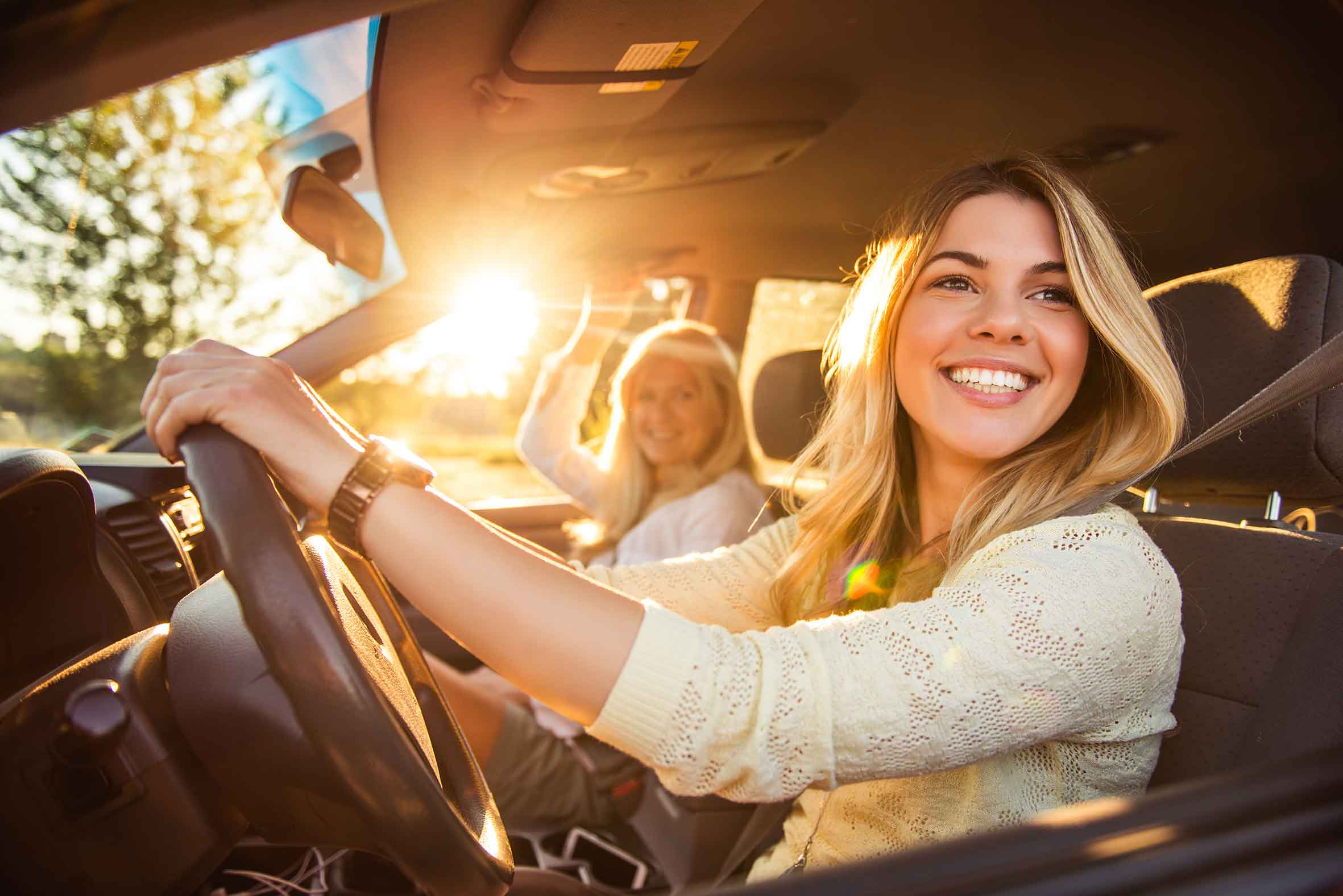 iStock/Georgijevic Frau mit Beifahrerin lenkt Pkw und muss Verkehrsregeln beachten
