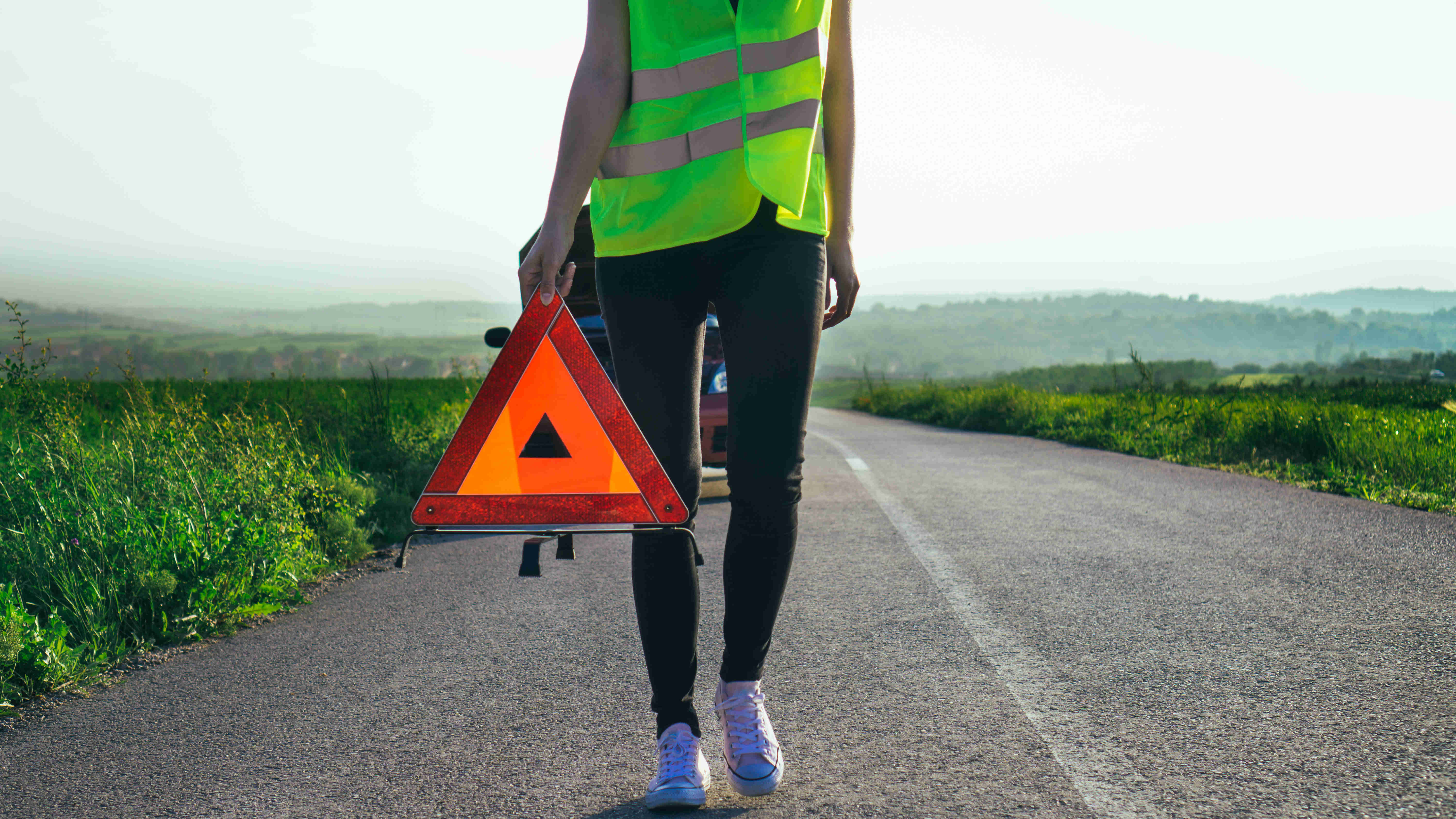 iStock/Milan Kostadinovic Frau mit Warnweste leistet Erste Hilfe im Straßenverkehr
