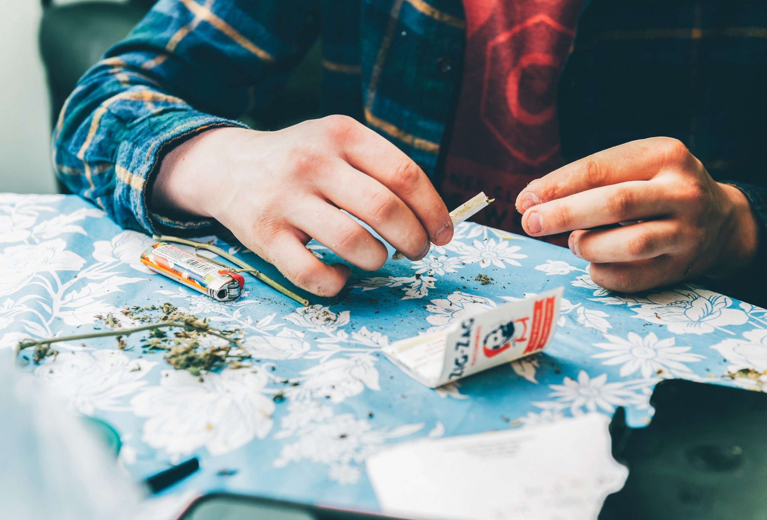 Pexels/Harrison Haines Das Bild zeigt die Hände eines Mannes, die einen Joint drehen.