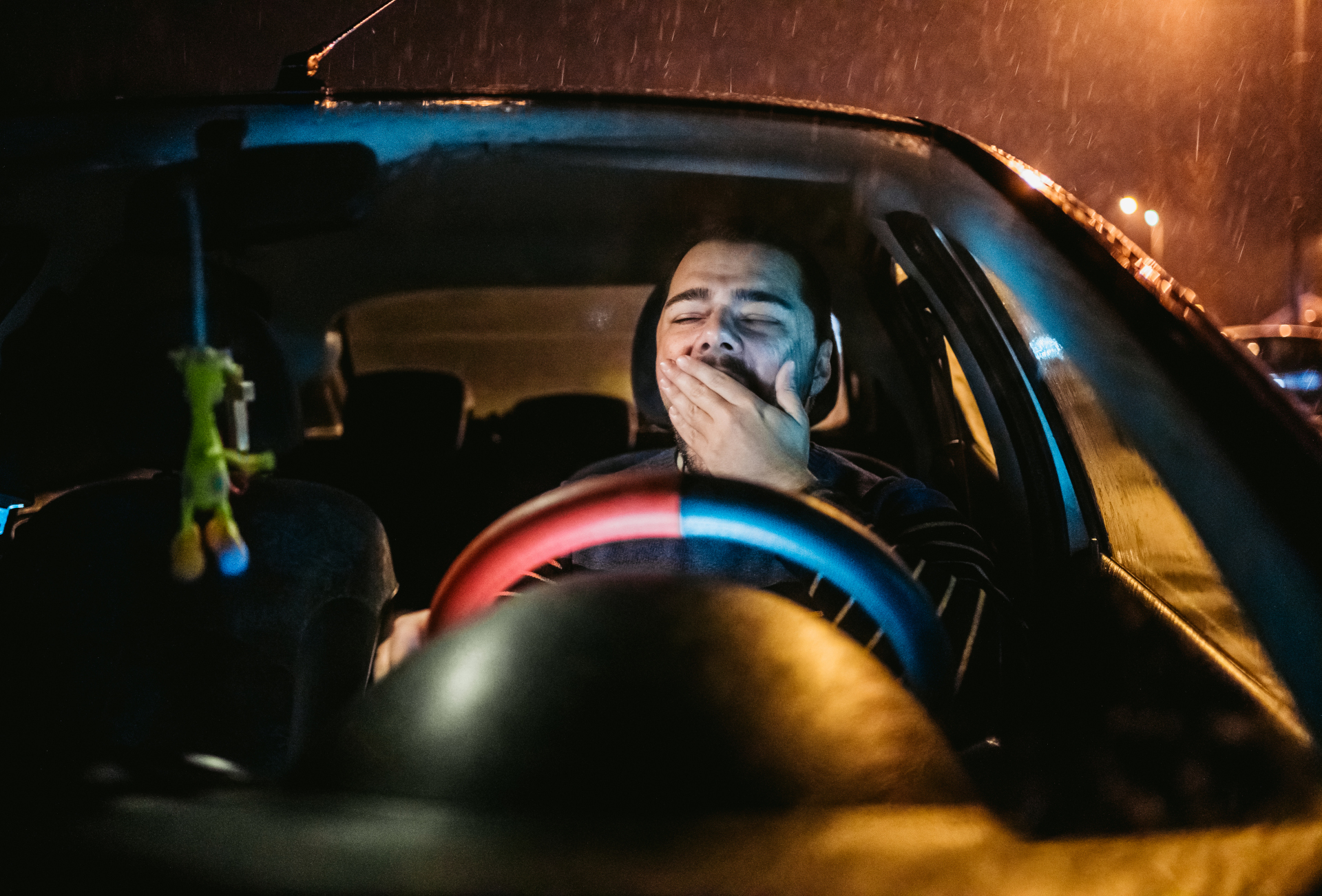 iStock/urbazon Person hinter dem Steuer gähnt